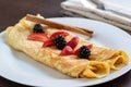 Appetizing crepes on white plate with strawberry and blackberry dressing Royalty Free Stock Photo