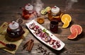 Delicious Asian dessert in white plate with steaming teapots, fruits, berries and spices. Asian menu. Wooden background.