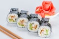 Appetizing fresh sushi rolls with rice, shrimps, avocado and cucumber on light background Royalty Free Stock Photo