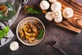 Appetizing fried champignons and basil leaves on a plate on the table top view