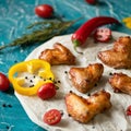 Appetizing fried chicken wings with pepper and tomato. Soft focus. Close up shot. Food concept. Square format or 1x1 for