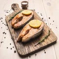 Appetizing fried salmon steak on a cutting board with lemon , rosemary and pepper unground close up Royalty Free Stock Photo