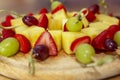 Appetizing fruit canapes of strawberry, pineapple and grapes on a wooden board. Close-up. Buffet snacks