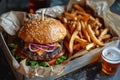 Savory gourmet burger with craft beer and artisanal fries on dark table Royalty Free Stock Photo