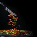 Appetizing green and red pieces of sweet paprika peppers in the air on a black background, a beautiful creative food background Royalty Free Stock Photo