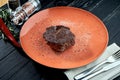 Appetizing grilled aged ribeye beef steak served in a plate on a wooden, black background. American BBQ culture