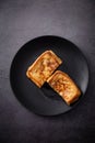 Appetizing grilled cheese toast sandwich displayed on a black plate, ready to be enjoyed Royalty Free Stock Photo