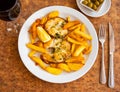 Appetizing grilled hake fillet with potatoes and spices closeup