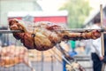 Appetizing grilled pork on the spit. Roasted leg of porkon traditional barbecue. Prepared of a ram pig baked pork meat Street food