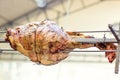 Appetizing grilled pork on the spit. Roasted leg of porkon traditional barbecue. Prepared of a ram pig baked pork meat Street food Royalty Free Stock Photo