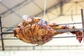 Appetizing grilled pork on the spit. Roasted leg of porkon traditional barbecue. Prepared of a ram pig baked pork meat Street food Royalty Free Stock Photo