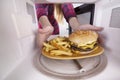 Appetizing hamburger and fries on plate inside the microwave Royalty Free Stock Photo