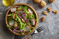 Appetizing and healthy low calorie salad with arugula, radishes, red cabbage and walnuts. In a wooden bowl and homemade look.