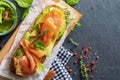 Appetizing and healthy smoked salmon with avocado and vegetables spinach sprouts, tomatoes, thyme on toast. Homemade look. Top Royalty Free Stock Photo