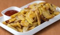 Appetizing home fried potatoes with onions, and ketchup served on a white plate