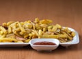 Appetizing home fried potatoes with onions, and ketchup served on a white plate