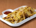 Appetizing home fried potatoes with onions, and ketchup served on a white plate