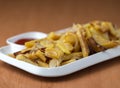 Appetizing home fried potatoes with onions, and ketchup served on a white plate