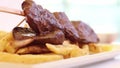 Appetizing hot heart beef peruvian dish called anticucho with fries.