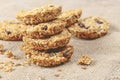 Appetizing image of oatmeal cookies stacked upon each other, with crumbs scattered around