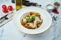 Appetizing Italian pasta with salmon, sun-dried tomatoes and parmesan in a white plate on a marble background. Fettuccine with Royalty Free Stock Photo