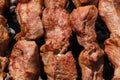 Appetizing juicy pork shish kebabs cooking on metal skewers on charcoal grill. Close-up view Royalty Free Stock Photo