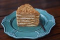 An appetizing piece of Napoleon cake on a blue plate. Close-up