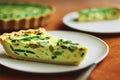 Appetizing pieces of asparagus tart with light yellow filling with greens
