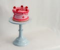 Appetizing pink cake with a cake stand, set against a white background