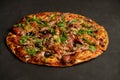 Appetizing pizza with smoked sausages bacon meat tomato cheese arugula Royalty Free Stock Photo