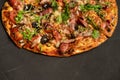 Appetizing pizza with smoked sausages bacon meat tomato cheese arugula Royalty Free Stock Photo