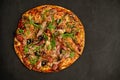 Appetizing pizza with smoked sausages bacon meat tomato cheese arugula Royalty Free Stock Photo