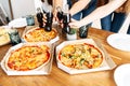 Appetizing pizza on the table and hands above it Royalty Free Stock Photo