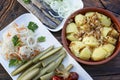 Appetizing potatoes, herring with onions and pickled vegetables on a wooden table. Traditional dishes of Russian cuisine. Close-up