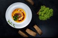 An appetizing pumpkin soup is served in a white plate in a restaurant Royalty Free Stock Photo