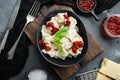 Appetizing ravioli with tomato sauce cheese and basil with basil parmesan and tomatoe in black bowl on gray background top