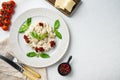 Appetizing ravioli with tomato sauce cheese and basil with basil parmesan and tomatoe on white plate on white background top