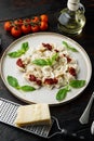 Appetizing ravioli with tomato sauce cheese and basil with basil parmesan and tomatoe on white plate on old dark wooden table