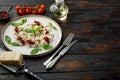 Appetizing ravioli with tomato sauce cheese and basil with basil parmesan and tomatoe on white plate on old dark wooden table