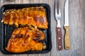 Appetizing ribs of baked pork in a sweet sauce with a crispy crust in a baking sheet