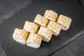 Appetizing sushi roll with Philadelphia tofu sesame cheese on a black stone plate