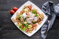 Appetizing salad with shrimp, lettuce, cheese, avocado and crackers on a white plate. Delicious and healthy seafood recipes. Low Royalty Free Stock Photo