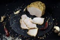 Appetizing sausage sliced on a slate board on a black background with spices and chilli selective artistic focus