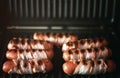 Appetizing sausages wrapped in bacon are grilled on a electric grill Royalty Free Stock Photo
