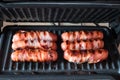 Appetizing sausages wrapped in bacon are grilled on a electric grill Royalty Free Stock Photo