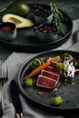 Appetizing slightly fried tuna with grilled vegetables close-up, traditional Italian cuisine, gray background, a dish