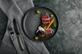 Appetizing slightly fried tuna with grilled vegetables close-up, traditional Italian cuisine, gray background, a dish