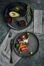 Appetizing slightly fried tuna with grilled vegetables close-up, traditional Italian cuisine, gray background, a dish