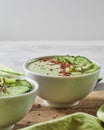 Green smoothies with a cucumber, kiwi and flax seeds in a plate on an old wooden board. Vegetarian food