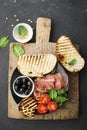 Appetizing snack with fried cheese haloumi, olives, bruschetta, tomatoes, olives, pine nuts, olive oil, honey and Royalty Free Stock Photo